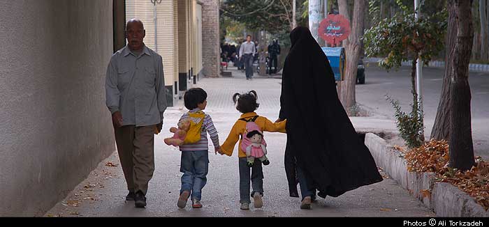 Mother and children on the way to school, town of Bastam, NE Iran.